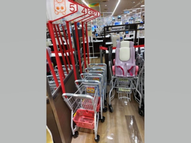 関西スーパー高槻店の子どもが押せる旗付き子ども用カートが並んでいる写真