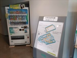 JT生命誌研究j館の入り口付近にある館内展示マップと自動販売機が置いてある写真