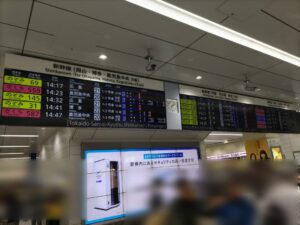 改札上に到着する新幹線が示された電子掲示板の写真