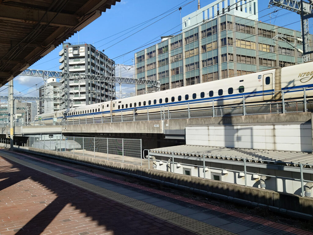 博多駅を新幹線のぞみが発車している写真