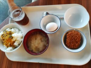 ご飯・お味噌汁・コロッケ・生卵の朝食の写真