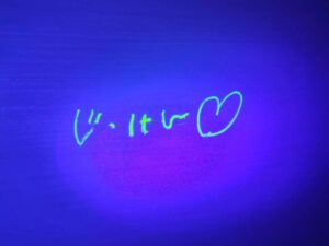 水で洗える光るクレヨンで書いた「じっけん♡」の文字がライトで光っている写真