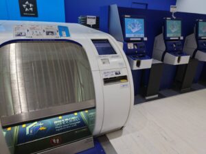 ANAの手荷物検査場手前に、自動でスーツケースを預けられる機械がある写真